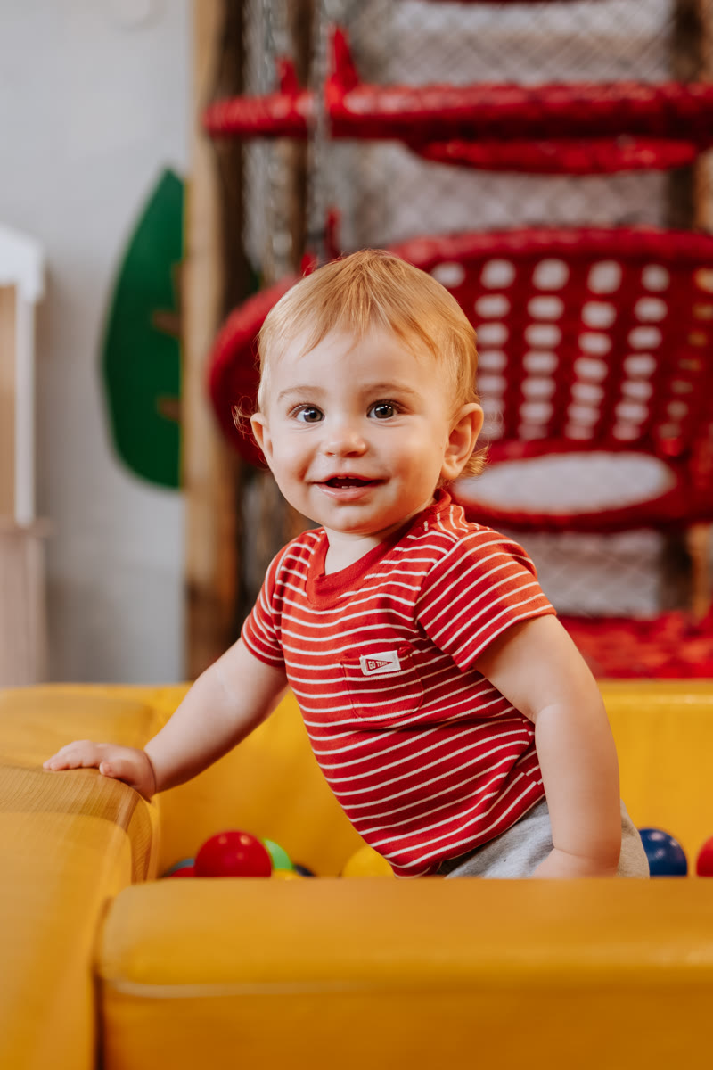 Bebê sorrindo no brinquedão amarelo
