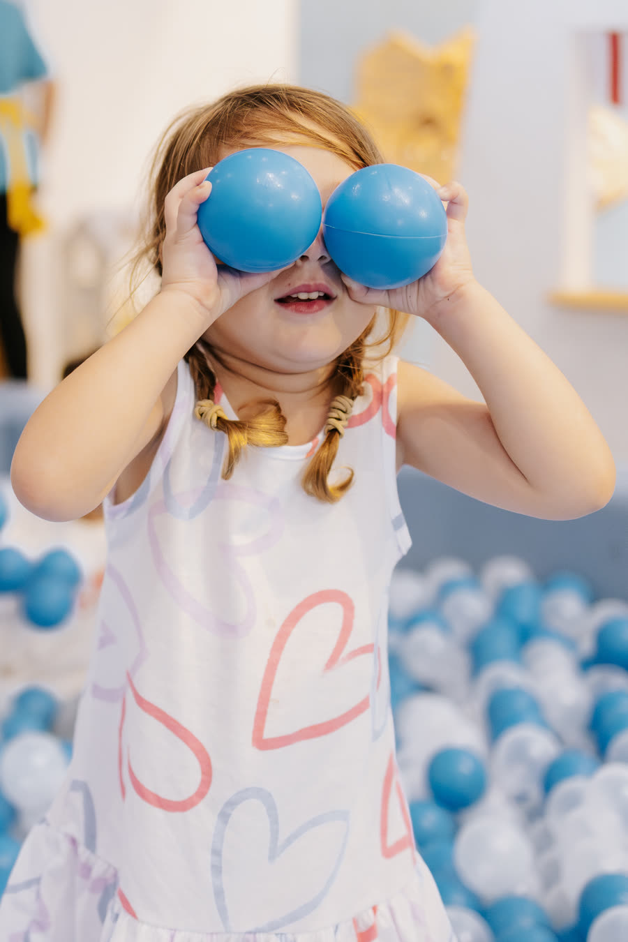 Menina brincando com duas bolinhas azuis nos olhos