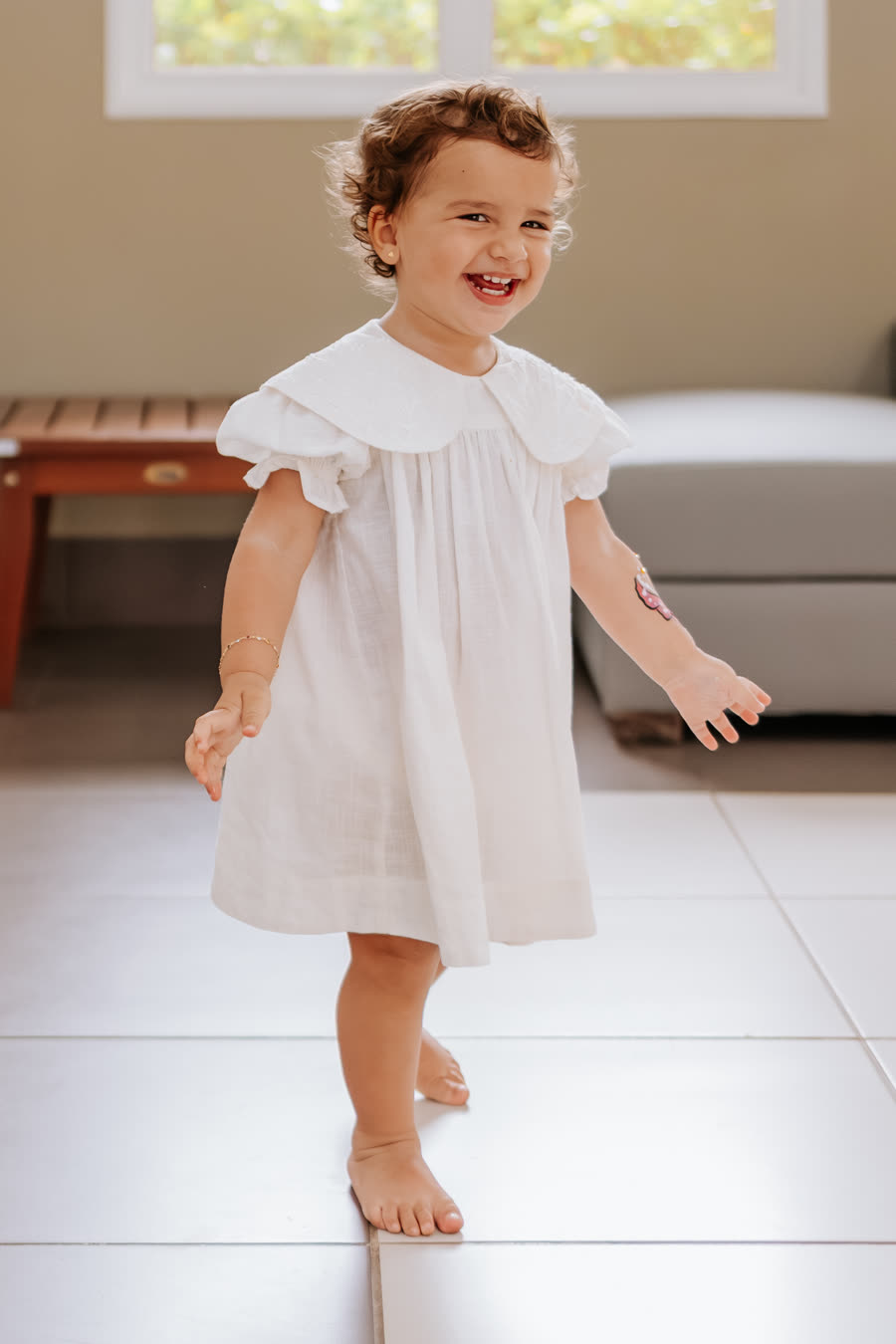 Menina de vestido branco gargalhando